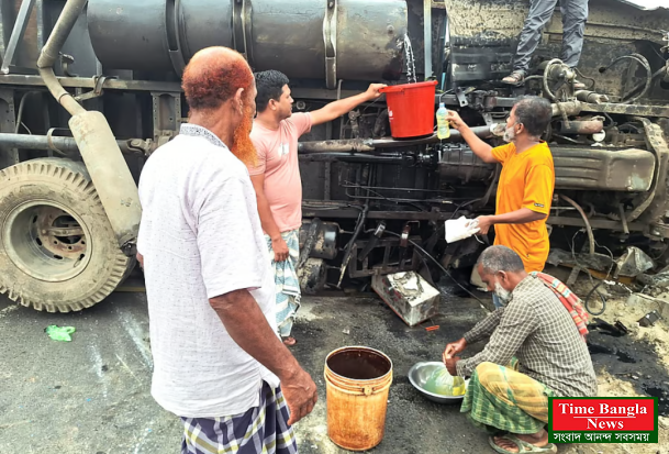 উলটে যাওয়া কাভার্ড ভ্যান  উদ্ধার না করে বালতি ভরে তেল নিতে ব্যস্ত মানুষ।